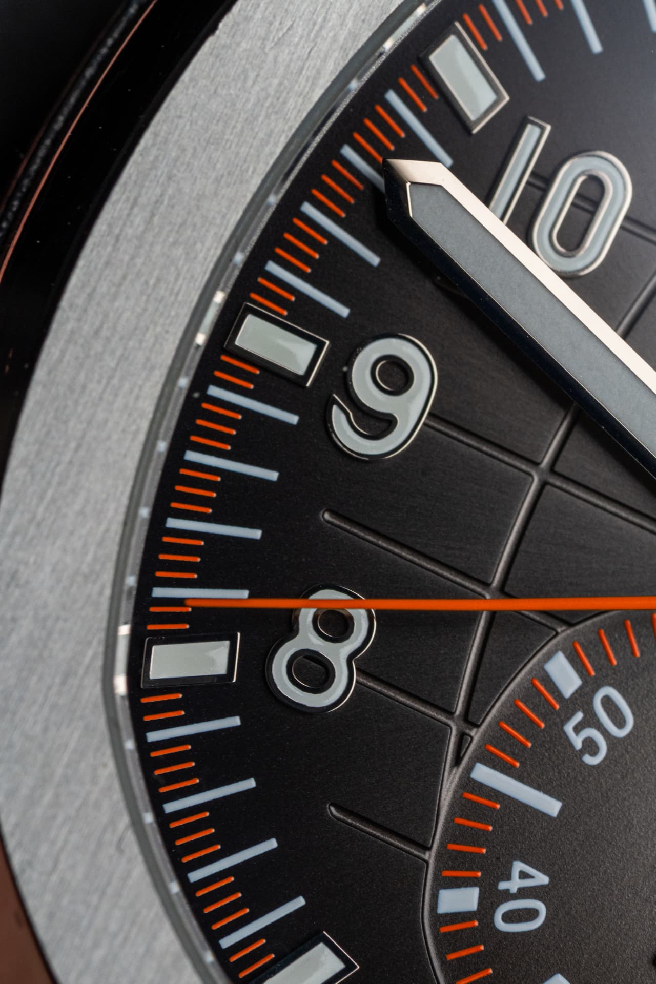 Close-up of a luxury watch dial with orange chronograph markings, Chrono Group product photography.